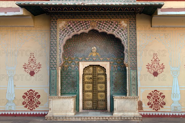 Brass gate with delicate wall paintings in the courtyard of the Chandra Mahal City Palace