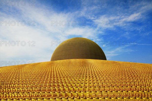 Buddhist temple Wat Phra Dhammakaya with golden Dhammakaya Buddha statues on the Chedi