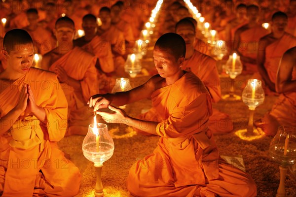 Monk lights candle