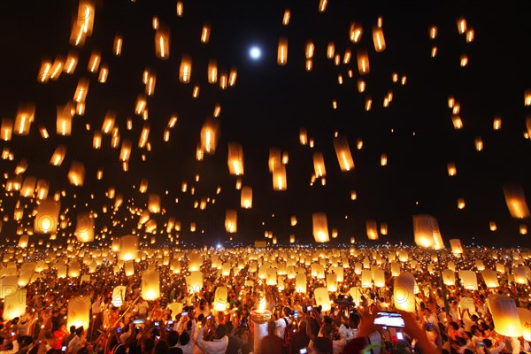 People letting sky lanterns rise