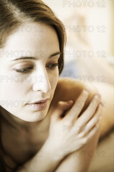 Young woman lying naked on the bed