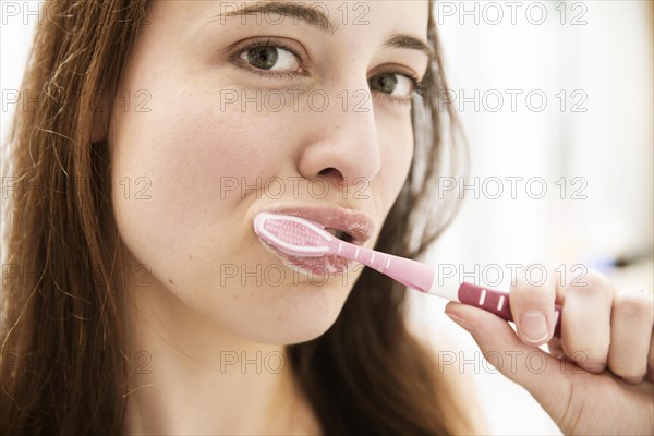 Young woman brushing her teeth