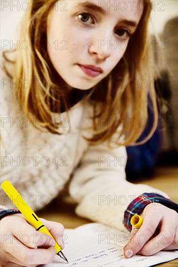 Girl doing her homework on the floor at home