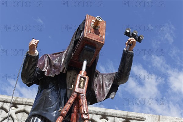 Man taking pictures with a plate camera on a tripod