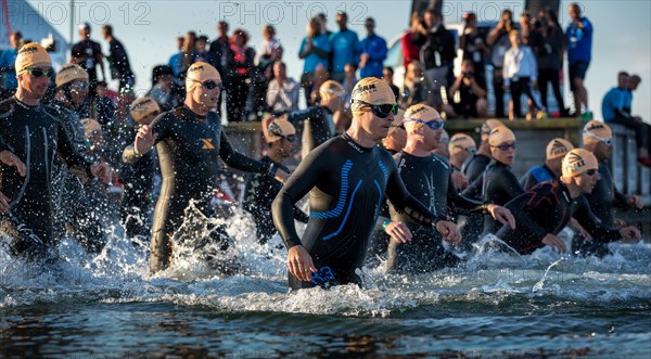 Participants of the Ironman Triathlon starting the race in the surf