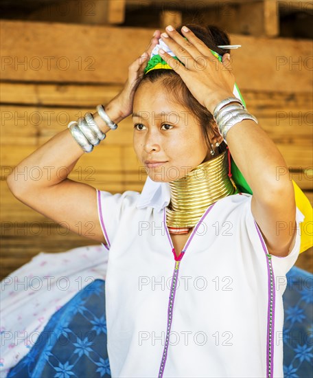 Young Kayan hill tribe woman does her hair in the morning