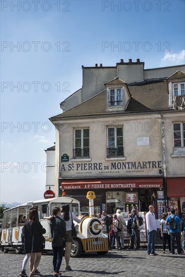 People and tourist train in front of souvenir shop