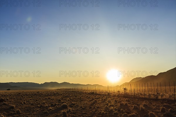 Farmland with fence at sunset