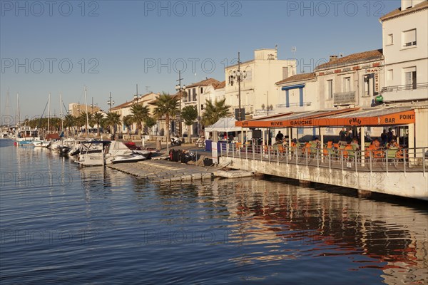 Promenade with restaurants and fishing boats at the harbor