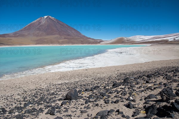 Laguna Verde with deposits of borax on the shore and snow on the mountains