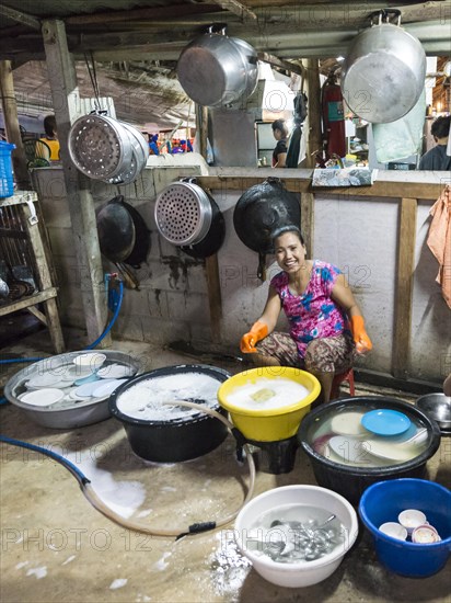 Thai woman washing dishes and pots