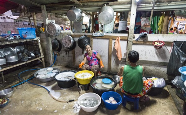 Thai woman washing dishes and pots