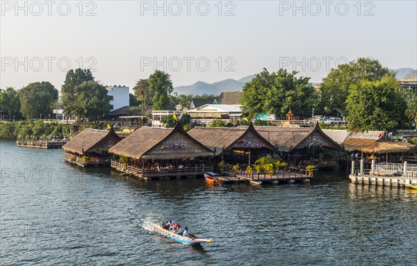 Longtail boat in front of floating houses