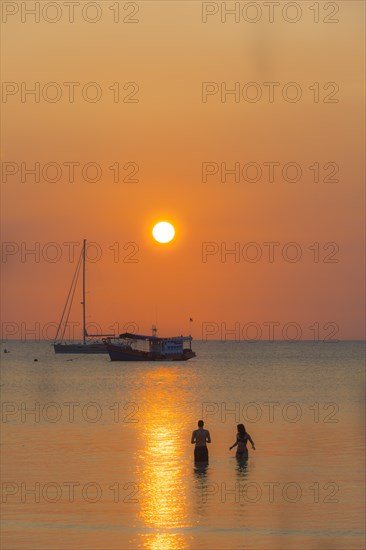 Two people standing in the water