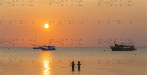 Two people standing in the water