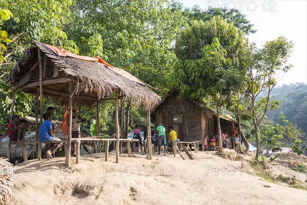 People sitting in front of wooden huts