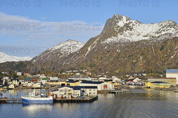 Harbor area with a boat in front of mountain scenery