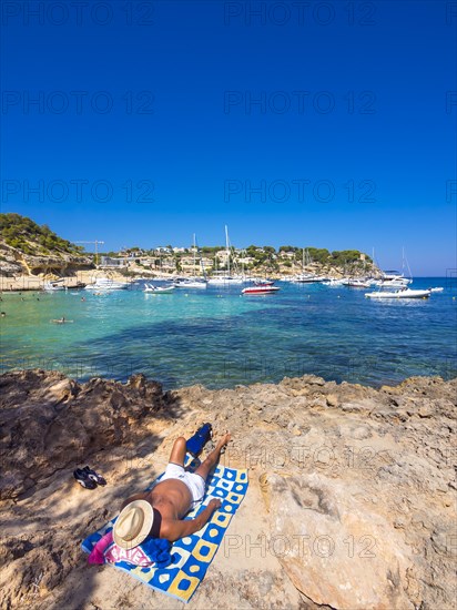 Holidaymaker lying at the bay of Portas Vells