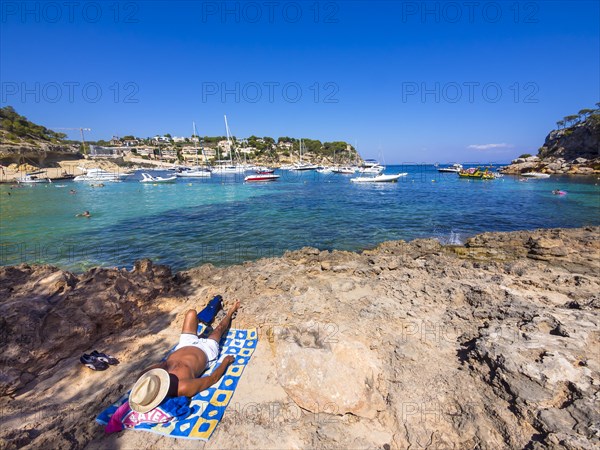 Holidaymaker lying at the bay of Portas Vells