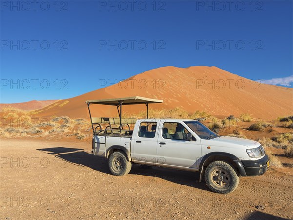 Terrain vehicle in front of a sand dune of the Namib Desert