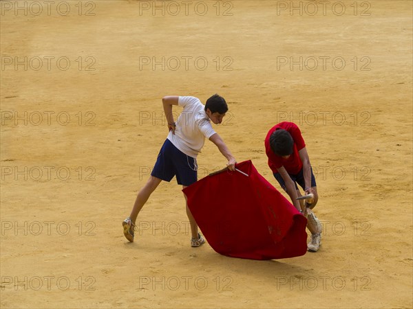 Toreros practicing bullfighting in bullring