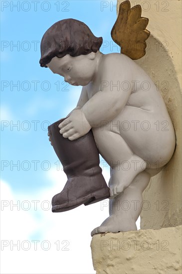 Figure of an angel with a boot