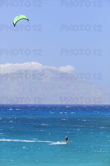 Kitesurfer in bright blue water