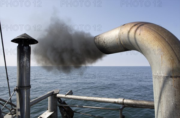 Trawler on a fishing trip with a dark marine diesel smoke cloud