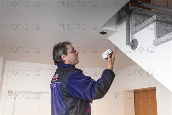 Caretaker with smoke detector in a stairwell