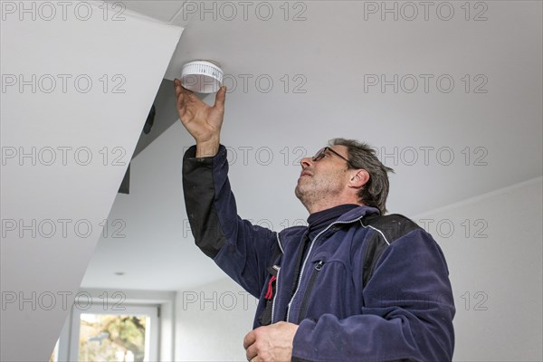 Caretaker with smoke detector in a stairwell