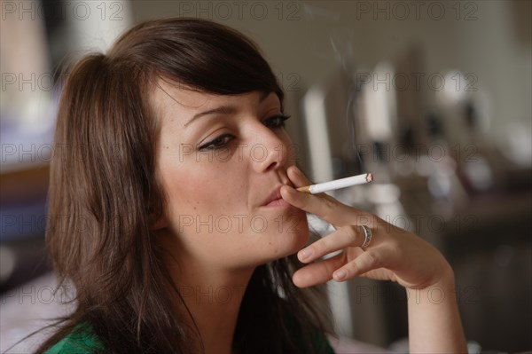 Young woman smoking in a bar or bistro