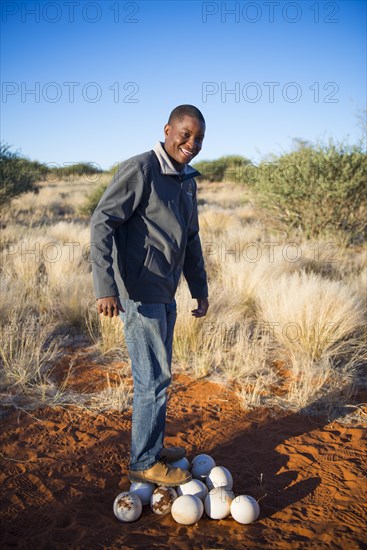 Local man standing on ostrich eggs