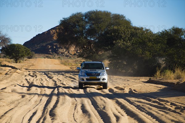 SUV driving on sandy road in south