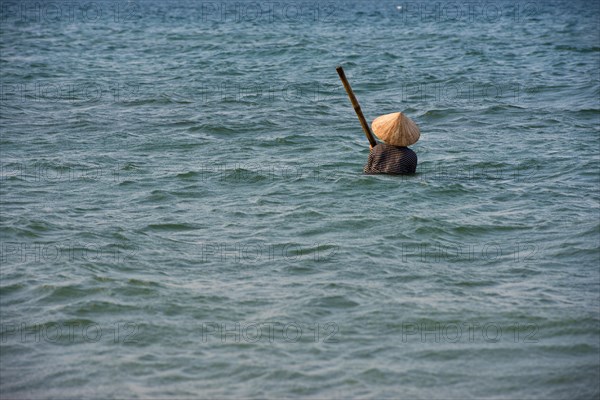 Mussel hunter wearing a straw hat