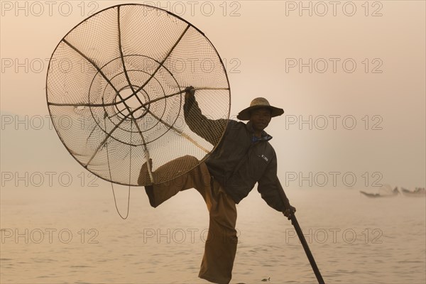 Fishermen rowing with one leg