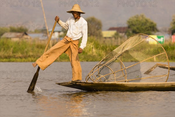 Fishermen rowing with one leg