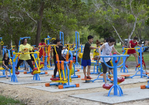 Hobby athletes training on open air fitness equipment
