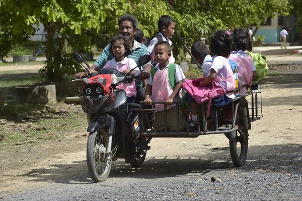 Old man with schoolchildren on a scooter