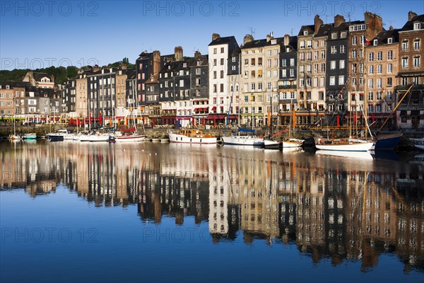 Houses and boats at the old harbor with reflections in calm water