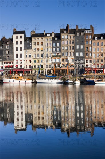 Houses at the old harbor with reflections in calm water