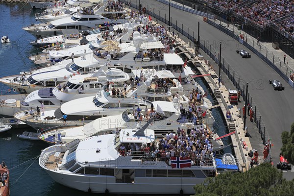 Viewers on yachts in Port Hercule at the track