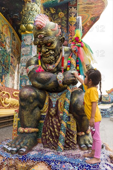 Girl rubbing bill at a Yaksa statue