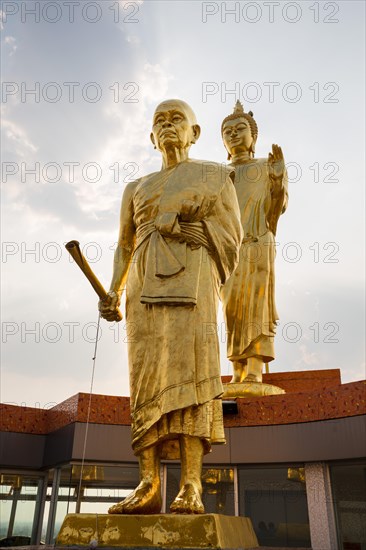 Golden statues of Buddha and monk Luang Phor Khoon on the roof of the Elephant Temple Thep Wittayakhom Vihara