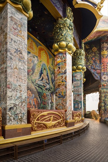 Columns with ceramic images in the gallery of the Elephant Temple Thep Wittayakhom Vihara