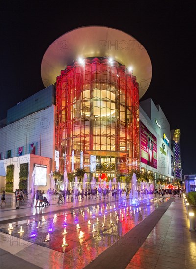 Siam Paragon shopping center at night with fountain in front of the illuminated glass facade