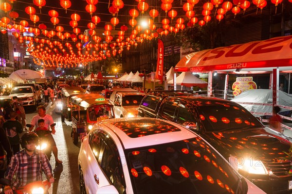 Red chinese lanterns reflecting on cars