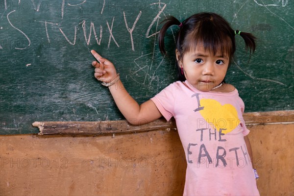 Little girl student pointing to a blackboard