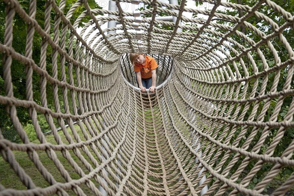 Boy crawling through a rope tunnel