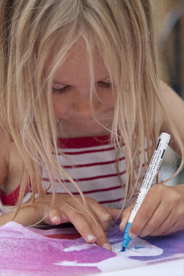 Little girl painting on fabric