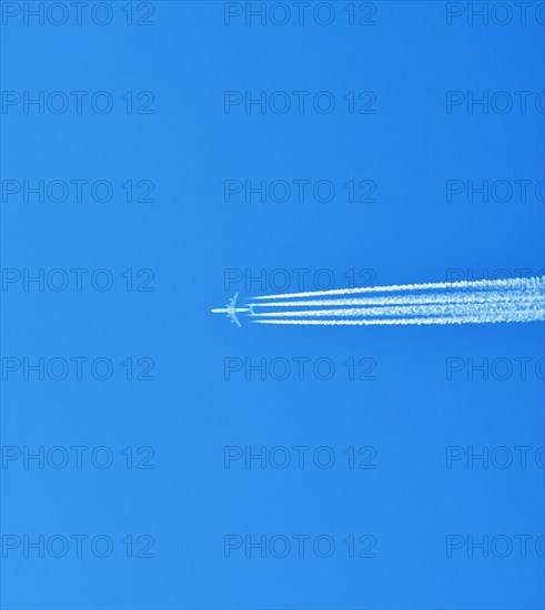 Aibus 380 widebody aircraft of Qatar Airlines with contrails in blue sky